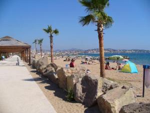a beach with palm trees and people on the sand at Fréjus plage B in Fréjus
