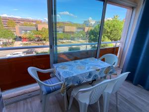 a table and chairs in a room with a window at Fréjus plage B in Fréjus