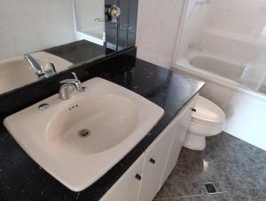 Un baño con un lavabo blanco y un inodoro. en De vuelta al sol, en Medellín