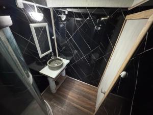 a small bathroom with a sink and a mirror at Cabaña con terraza vista al río in Melipeuco