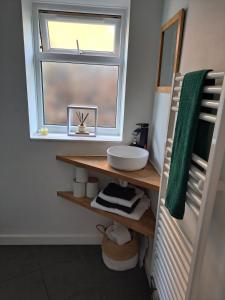 ein Badezimmer mit Waschbecken und Fenster in der Unterkunft Whole Annexe in our family home & private entrance in Ipswich + 6 Fotos