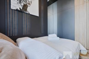 a bedroom with two beds with white sheets at Jaracza Exclusive by LookAp - darmowy parking w centrum!! in Łódź
