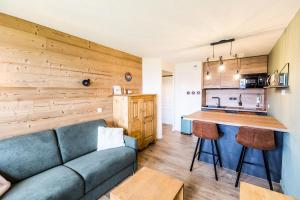 a living room with a couch and a kitchen at Résidence LE RAMI - 2 Pièces pour 4 Personnes MAE-6603 in Montchavin