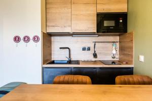 a kitchen with a sink and a microwave and a table at Résidence LE RAMI - 2 Pièces pour 4 Personnes MAE-6603 in Montchavin