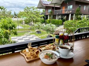 a tray of food and a cup of coffee on a balcony at Nature Peace Home in U Thong
