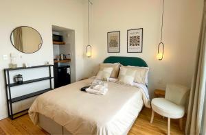a bedroom with a bed with a chair and a mirror at Rambla Bliss Suites con Vista al Mar in Montevideo