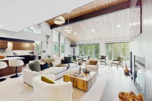 a living room with white furniture and a kitchen at Booth Falls Chalet in Mid Vail