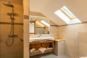 a bathroom with a sink and a shower with a skylight at Gasthof Neuwirt in Eugendorf +27 photos