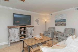 Ono IslandにあるSea Spray 505Wのテレビ、ソファ、テーブルのあるリビングルーム