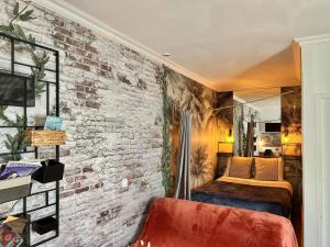 a bedroom with a brick wall and a bed at Studio - Cosy -Centre- Lorient- & Gare in Lorient