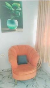 an orange chair with a blue pillow in a room at Graceville Haven in Abeokuta +3 photos