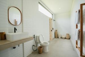 a bathroom with a sink and a toilet and a mirror at Honey Villa Canggu in Canggu +12 photos