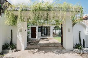 an entrance to a white house with plants at Honey Villa Canggu in Canggu