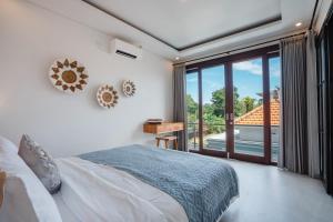 a bedroom with a bed and a large window at Honey Villa Canggu in Canggu