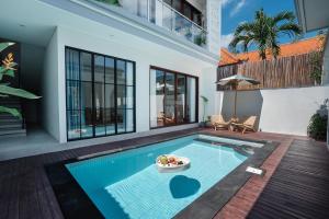 a swimming pool in the middle of a house at Honey Villa Canggu in Canggu