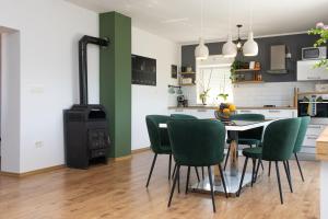 a kitchen and dining room with a table and green chairs at Guest house "The View" - with a pool in Donje Polje