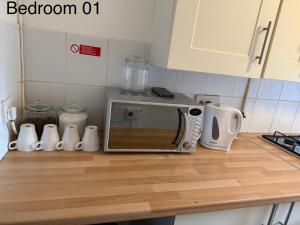 a kitchen counter with a microwave on top of it at 5 Brunswick St - Bedroom 01 downstairs in Bristol