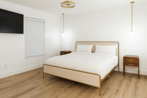 ランドオレイクスにあるLuxury Modern Retreat 5 Minutes to Tampa Outletのベッドと薄型テレビのある寝室