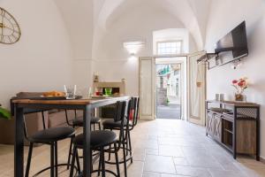 a kitchen and dining room with a table and stools at LA MAISON Di FILOMENA in Aradeo