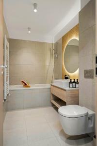 a bathroom with a toilet and a tub and a sink at SB Nest Apartment in Braşov