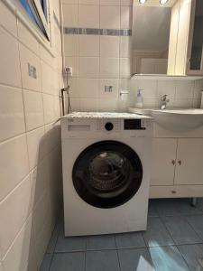 een wasmachine in een badkamer met een wastafel bij Kavala Centre Spot in Kavala