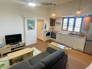 a living room with a couch and a kitchen at La Kazadoo in Piton Saint-Leu