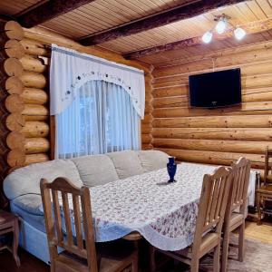 a room with a table and a tv in a cabin at Cottage Karinka in Bukovel +71 photos