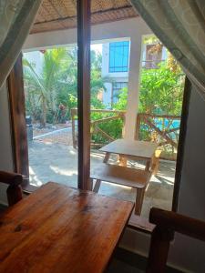 a table and a bench in a room with a window at Sailorvilla and apartments in Jambiani