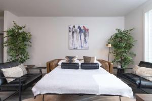 a bedroom with a bed with two chairs and a painting at Trinity River - Skyline Views - King bed in Fort Worth