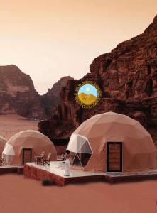 a person standing in front of three tents in the desert at RUM BUBBLES VIEW MARS lUXURY CAMP in Wadi Rum