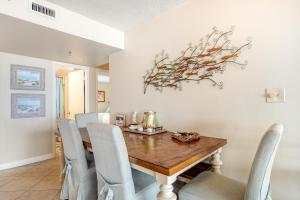 Un comedor con mesa y sillas de madera. en Magnolia House at Destin Pointe 412, en Destin
