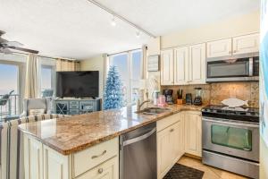 una cocina con armarios blancos y un árbol de Navidad en Magnolia House at Destin Pointe 412, en Destin 22 fotos más