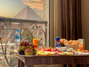 开罗Hammis Pyramids View INN的一张有食物的桌子，可以欣赏金字塔的景色