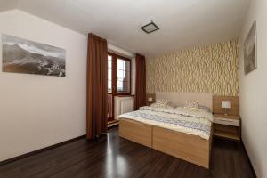 a bedroom with a bed and a window at Apartmán SkyNest Tatry - Veľká Lomnica in Veľká Lomnica