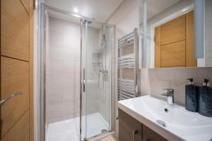 a bathroom with a shower and a white sink at Luxury 5-Bed, Windsor Sleeps 9, Private Parking in Windsor +64 photos