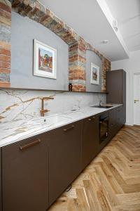 - une cuisine avec un évier et un mur en briques dans l'établissement Luxury living in the heart of Tallinn in 3 room apartment, à Tallinn