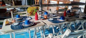 a wooden table with blue plates and hats on it at Pousada Cavallitos d'Amar in Ilha de Boipeba