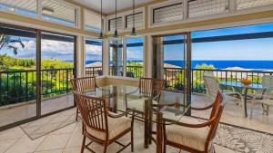 a dining room with a glass table and chairs at Kapalua Ridge Villa 1112 in Kapalua +35 photos