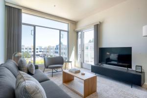 een woonkamer met een grijze bank en een tv bij Palo Alto 2br w pool parking nr dining SFO-1418 in Palo Alto