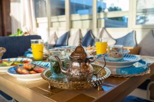 a table with a tea kettle and plates of food at Riad Tassili Chaouen in Chefchaouene