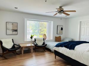 a bedroom with a bed and two chairs and a window at Luxury New 5-bedroom 4- bathroom Single House in Surrey