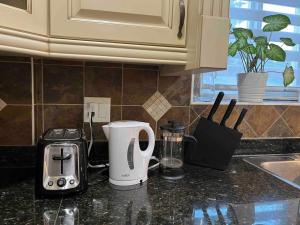 a kitchen counter with a coffee maker and a toaster at Luxury New 5-bedroom 4- bathroom Single House in Surrey