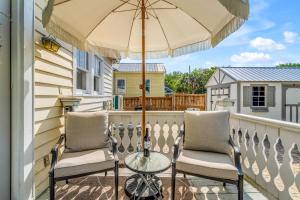 a balcony with two chairs and an umbrella at Downtown Pensacola Historic Getaway in Pensacola