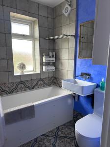 un bagno con vasca, lavandino e WC di Three bedroom house in rural village a Drayton