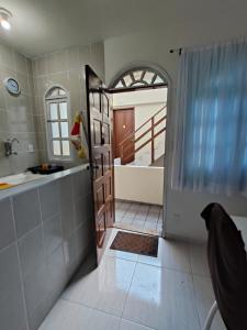 a bathroom with a tub and a sink and a door at Estadia Férias e Trabalho in Vila Velha