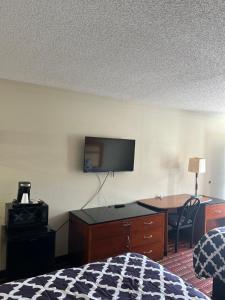 a hotel room with a bed and a desk and a television at peach tree inn in Saint George