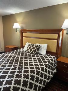 una camera con un letto bianco e nero con due lampade di peach tree inn a Saint George Altre 2 foto