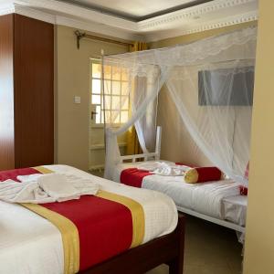 a bedroom with two beds and a window at GreenHaven Siaya Cottages in Siaya