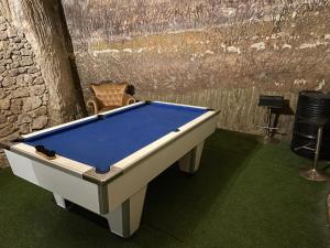 Una mesa de billar sobre un suelo verde con una silla. en JC's House of Happiness, en Cabrières-dʼAigues