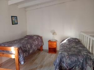 a bedroom with two beds and a table with a lamp at Apart Vital 3 in El Calafate